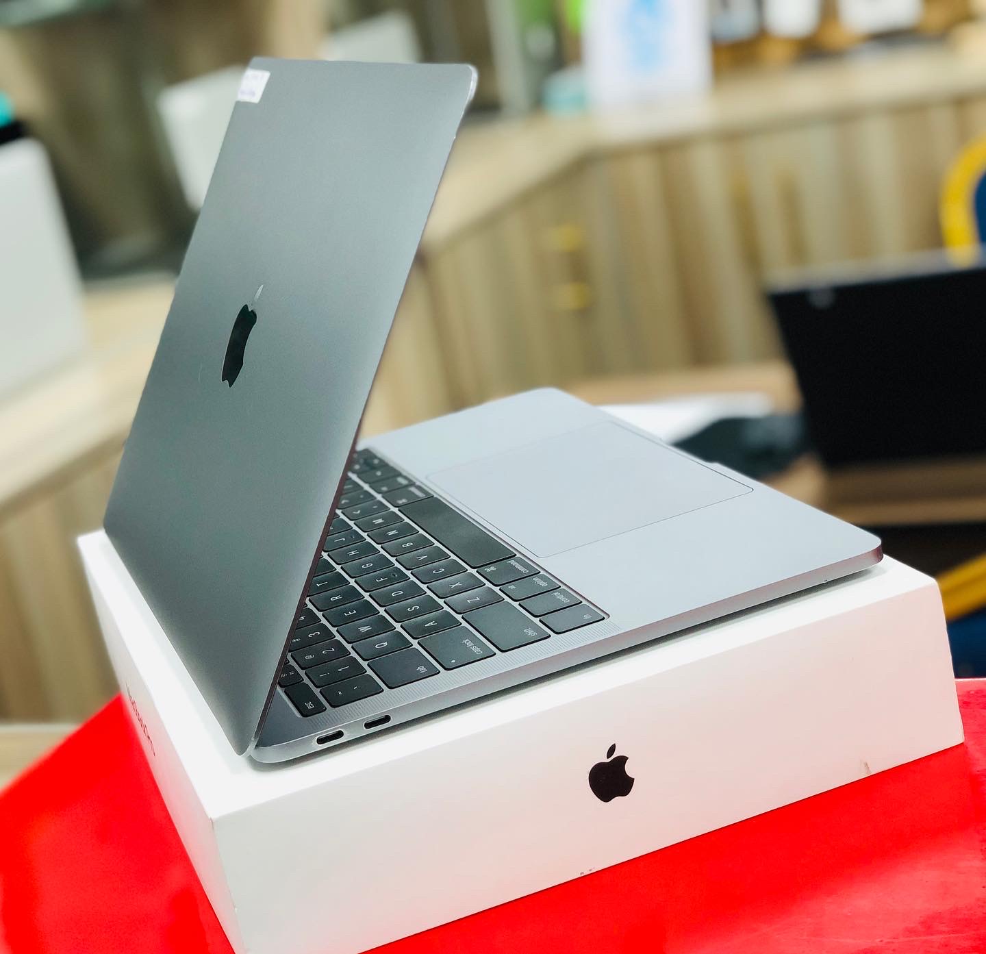 A space gray MacBook Pro 2017, open, resting on its retail box